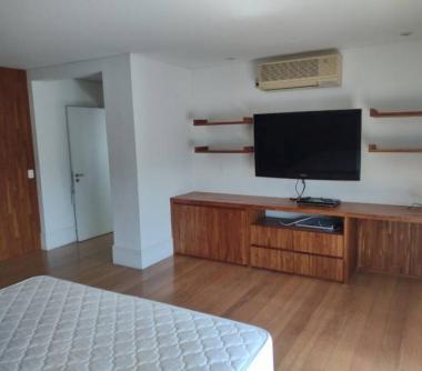 Quarto com armários e rack com televisão 