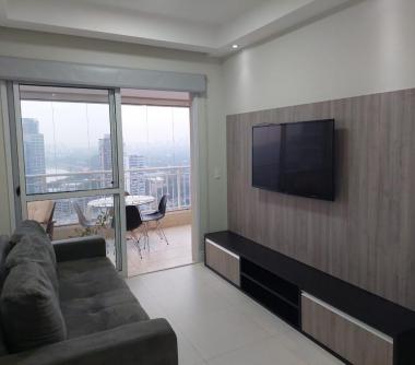 Sala com sofá, painel de Tv e porta balcão em vidro 