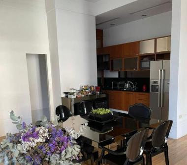 Cozinha americana com armários embutidos, inetegrada com sala de jantar com mesa de vidro preto com 6 lugares