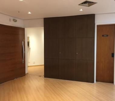 Sala com  detalhes em madeira (piso, portas e painel), paredes na cor branca, sala moderna  ótimo investimento, todos ambientes com ar-condicionado .