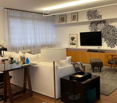 Sala de estar  com TV e prateleiras com decoração 